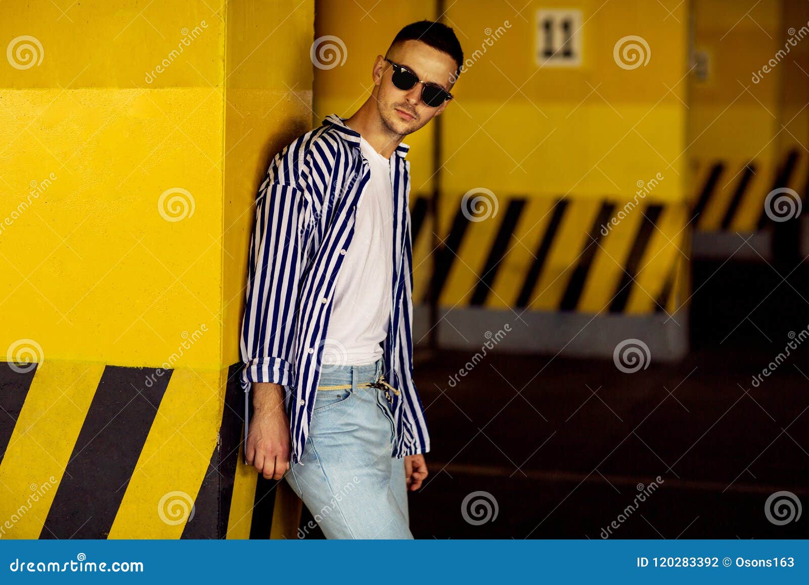 Fashion Guy in a Striped Shirt is Standing Near a Yellow Parking Stock ...