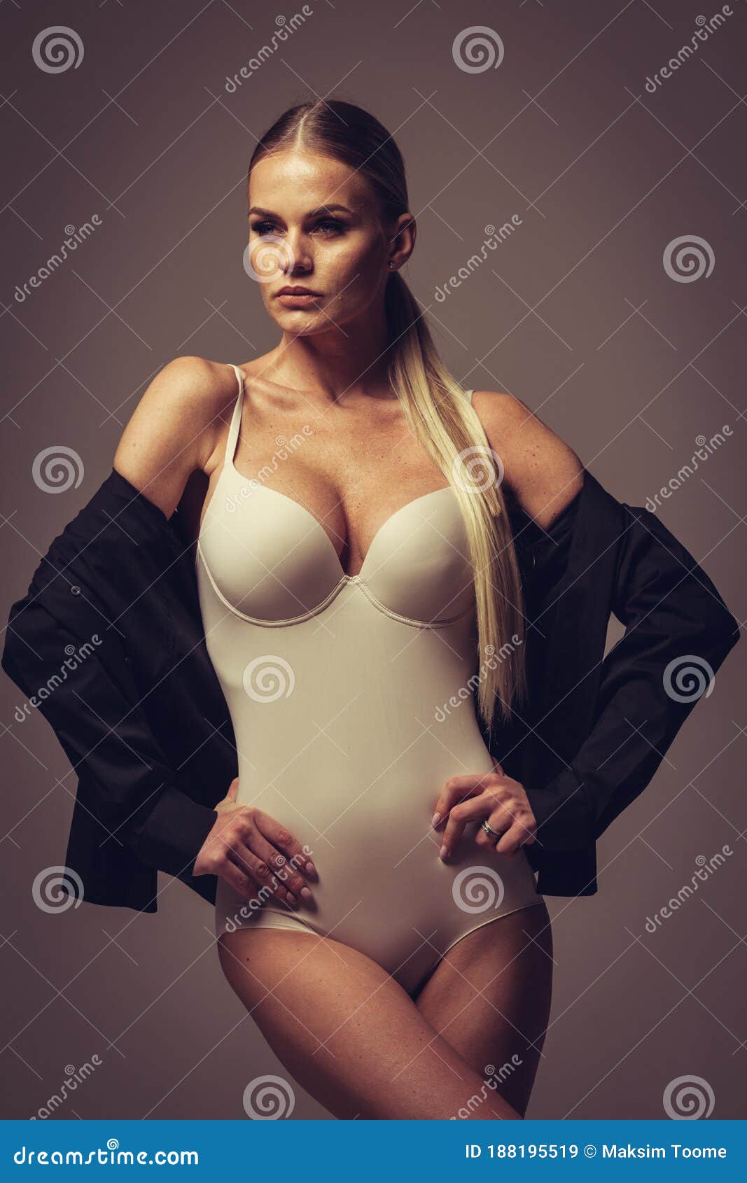 Fashion and Lingerie Concept - Beautiful Blond Lady Portrait in Nude Color Corset and Black Shirt on Gray Stock Image picture