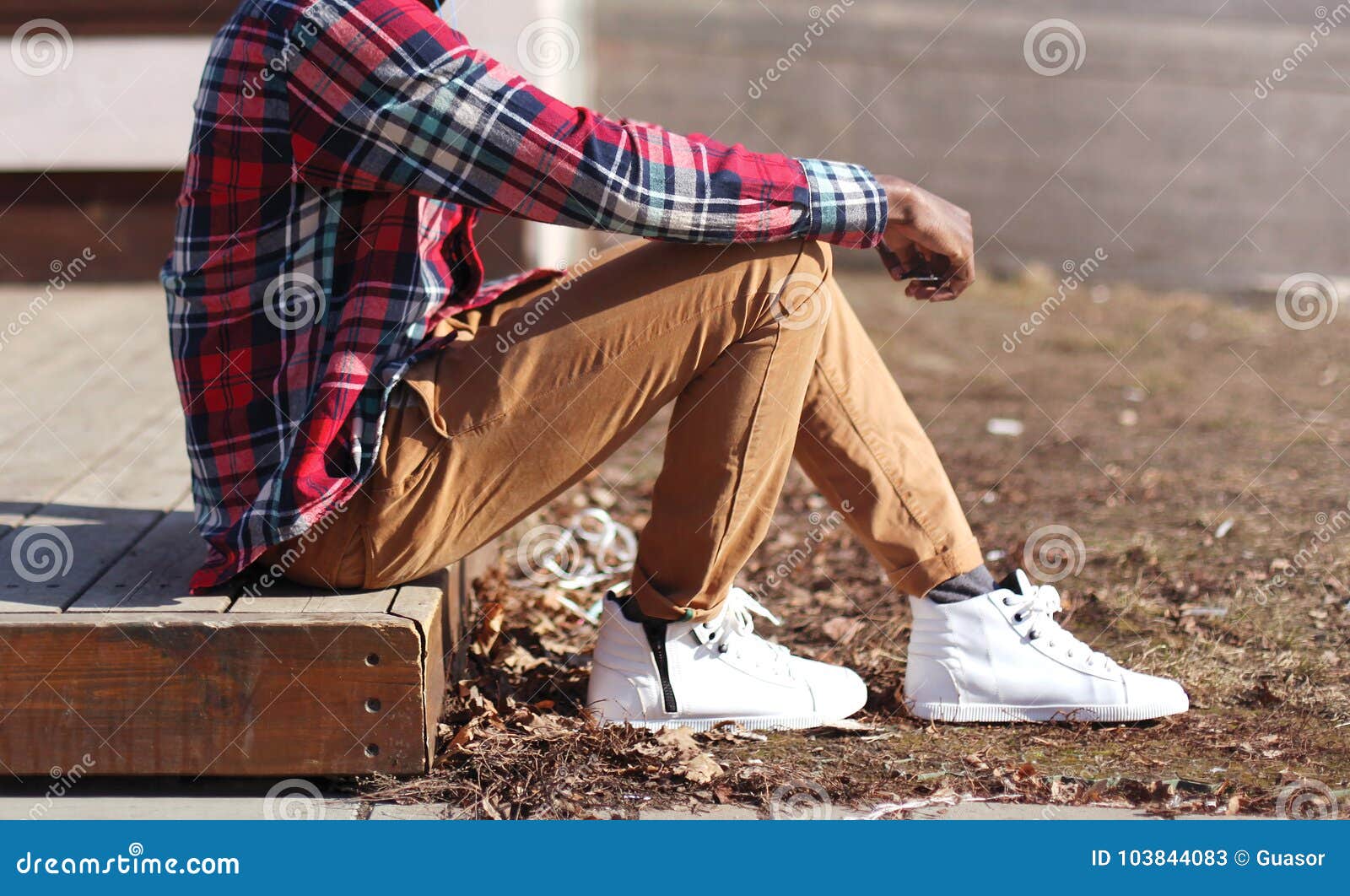 Fashion Man in a Plaid Red Shirt and Casual Sneakers Sits Stock Image ...