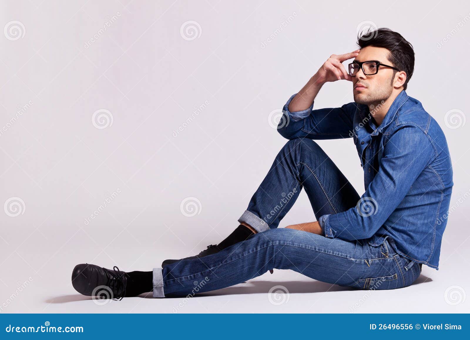 Young Black Man Posing Seated on Studio Floor - a Royalty Free Stock Photo  from Photocase
