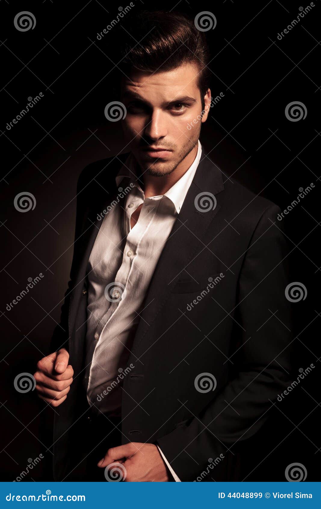 Attractive young man in a brown leather jacket pose in studio. Stock Photo  | Adobe Stock