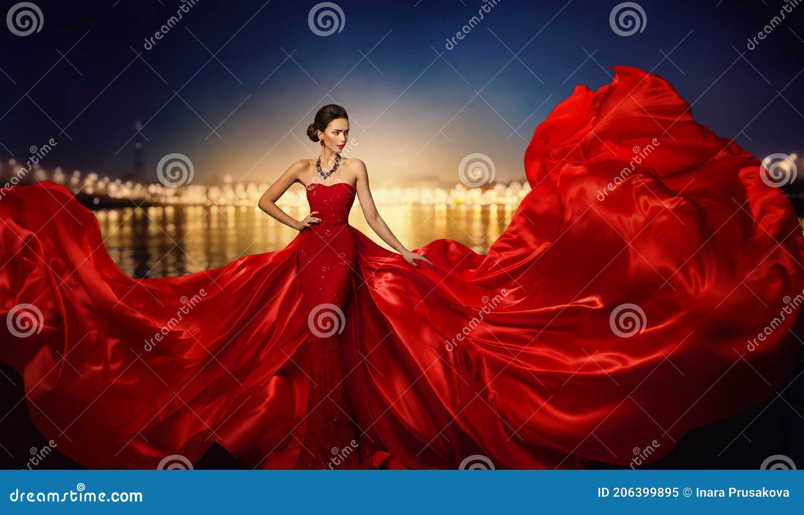 fashion model in fluttering dress in night city street lights, elegant woman in red long gown beauty portrait