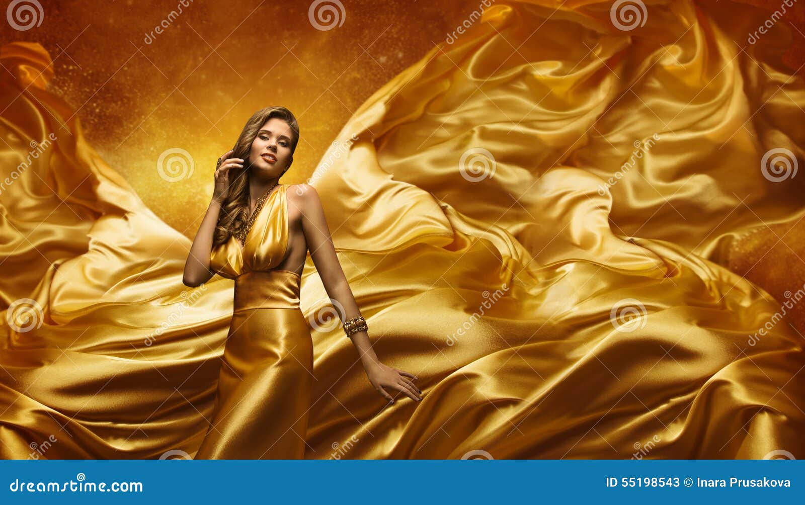 fashion model in gold dress, beauty woman posing flying cloth