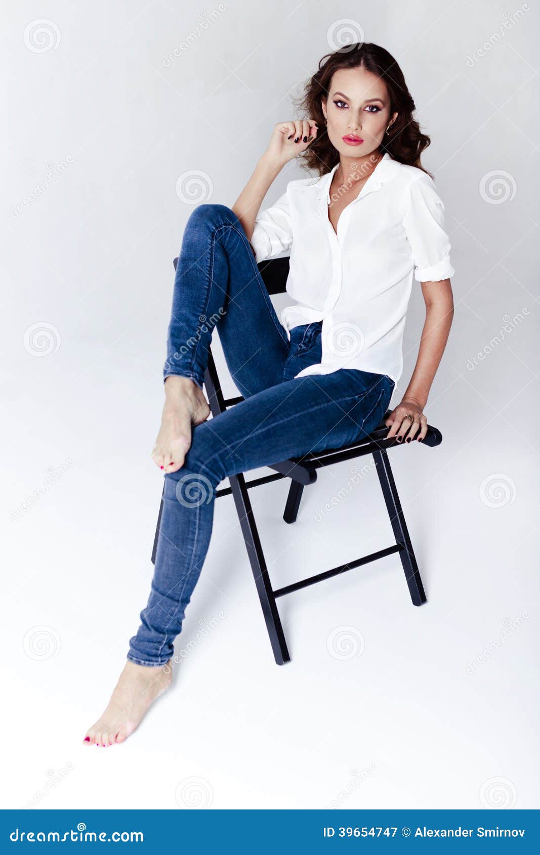 Fashion Model Sitting on a Chair in a Blouse and Jeans Barefoot Stock ...