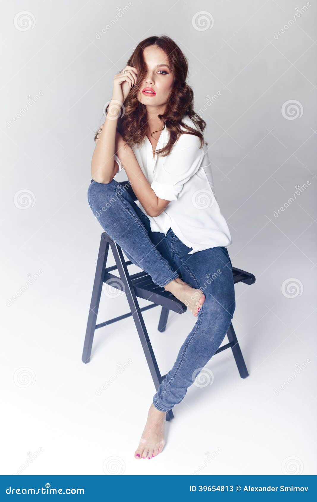 Fashion Model Sitting on a Chair in a Blouse and Jeans Barefoot Stock ...