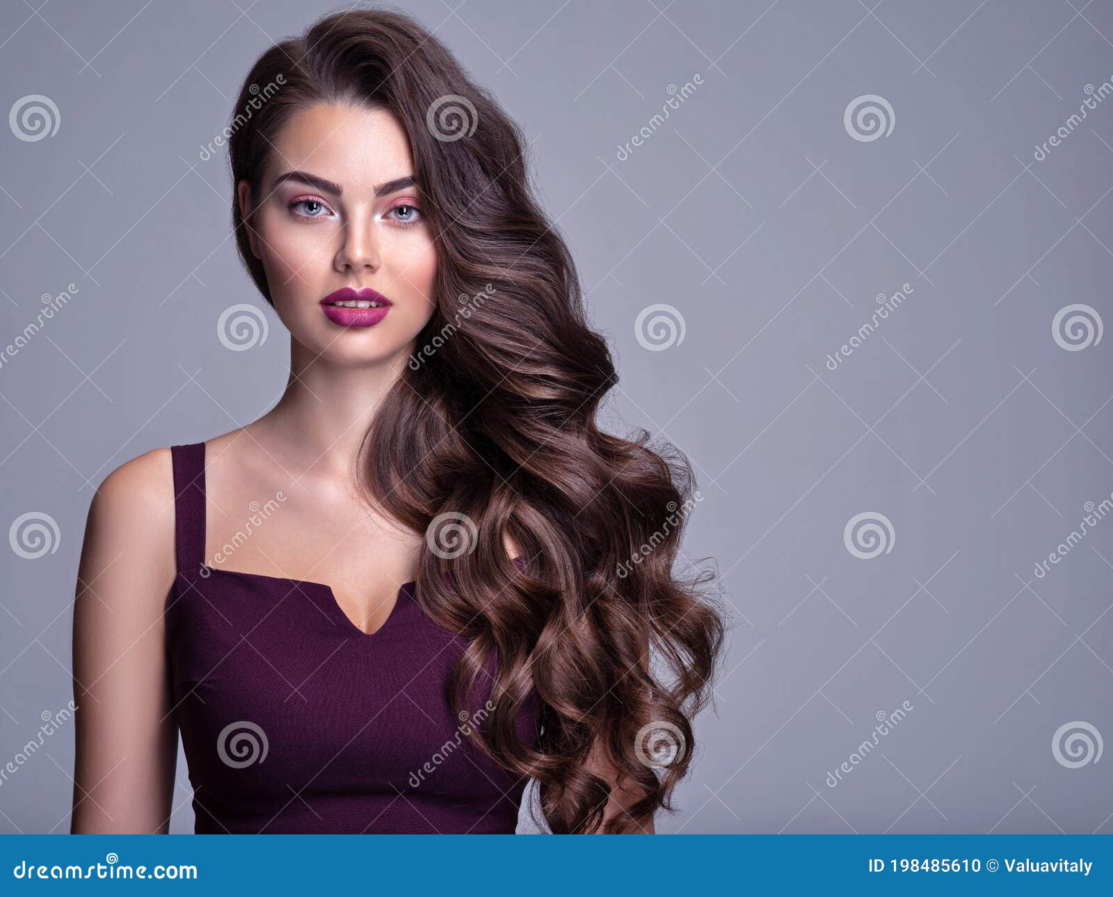Face of a Beautiful Woman with Long Brown Curly Hair. Fashion Model with Wavy  Hairstyle. Attractive Young Girl with Curly Hair Stock Photo - Image of  studio, girl: 198485610