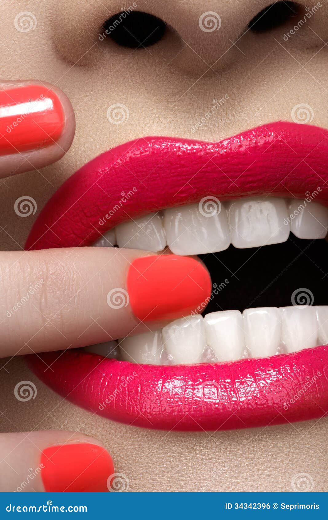 Fashion pink lips make-up and nails polish. Close-up of woman s lips with fashion hot pink lipstick makeup. Beauty macro make-up with bright magenta color on nails. Healthy white teeth