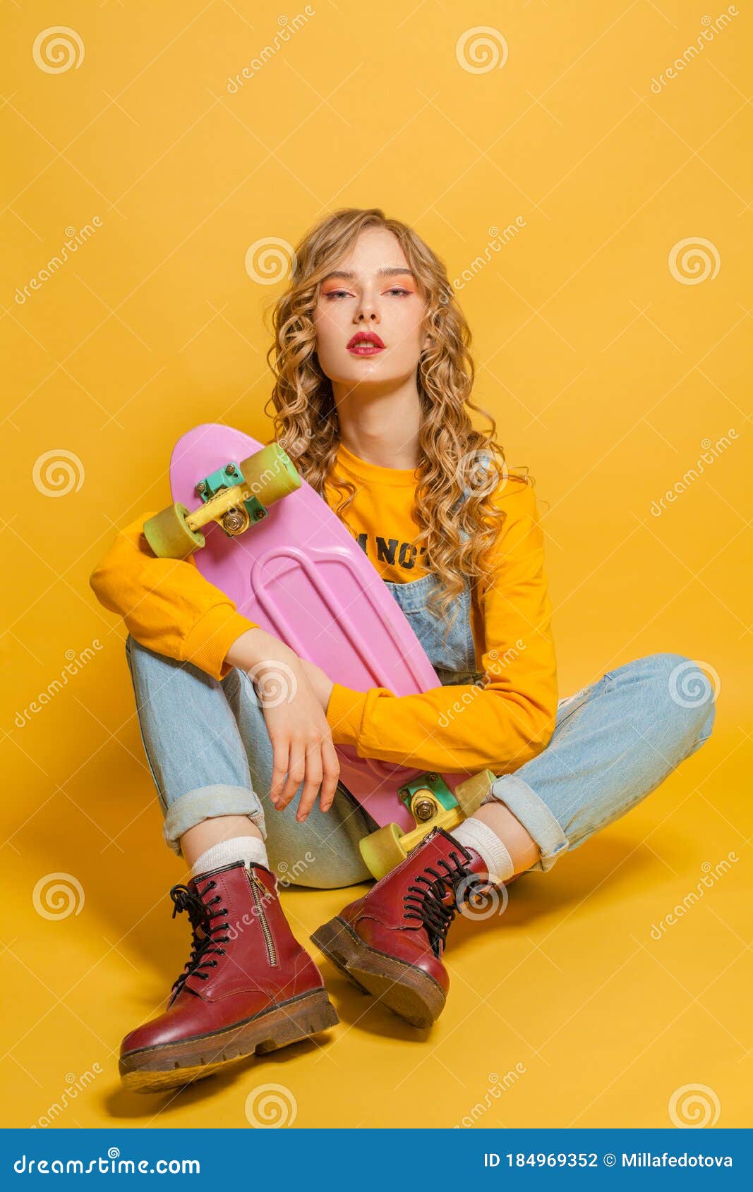 Fashion Woman Sitting on Skateboard on Bright Yellow Background Stock ...