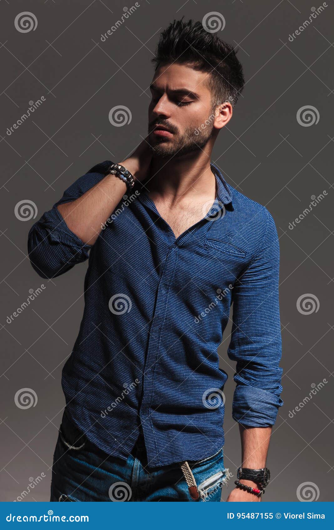 Fashion Young Man Holding Hand Behind Neck and Looks Down Stock Image ...