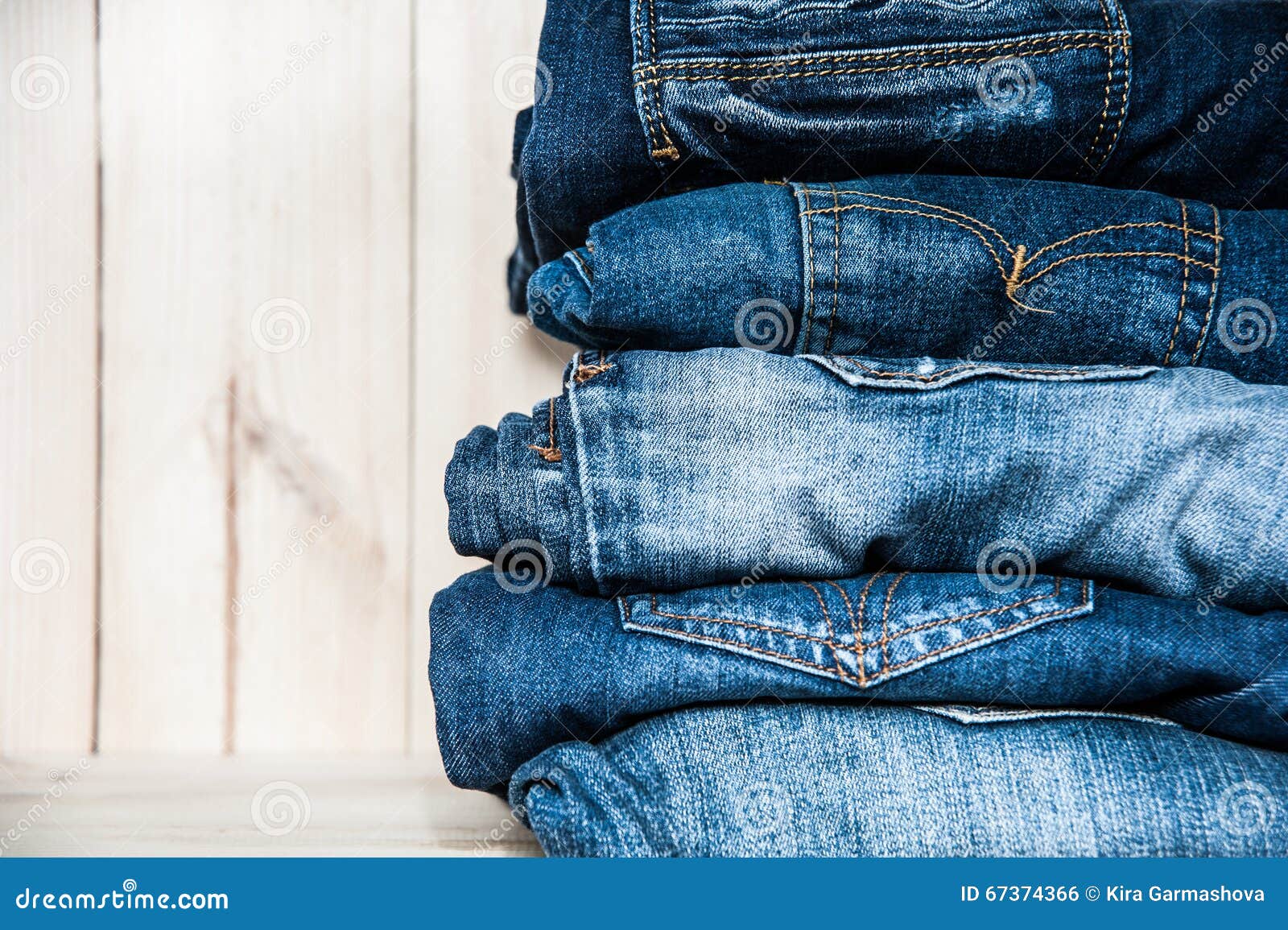 Fashionable Clothes. Pile of Jeans on a Wooden Background Stock Photo ...