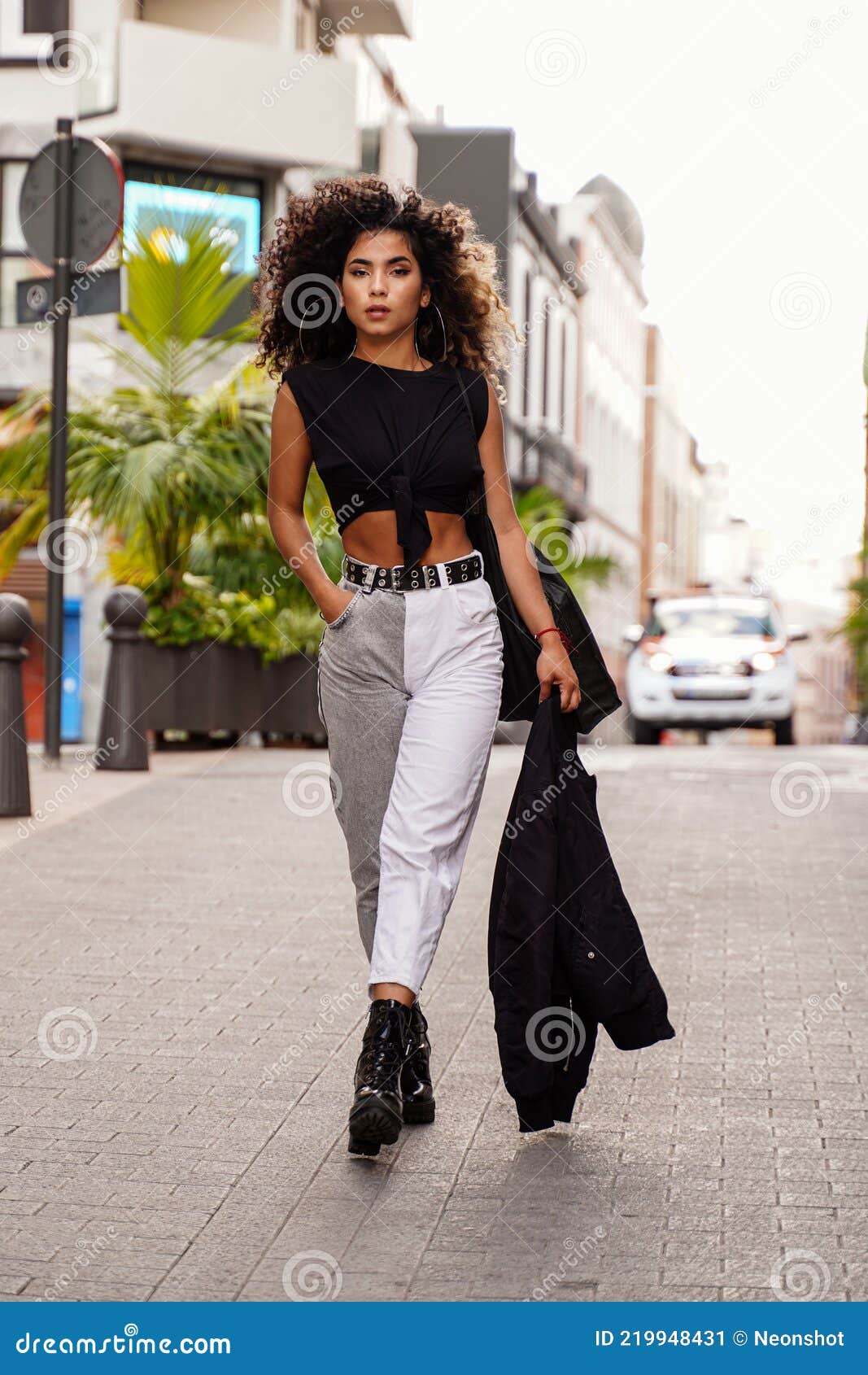 Young afro colombian woman sitting at cafe drinking coffee and