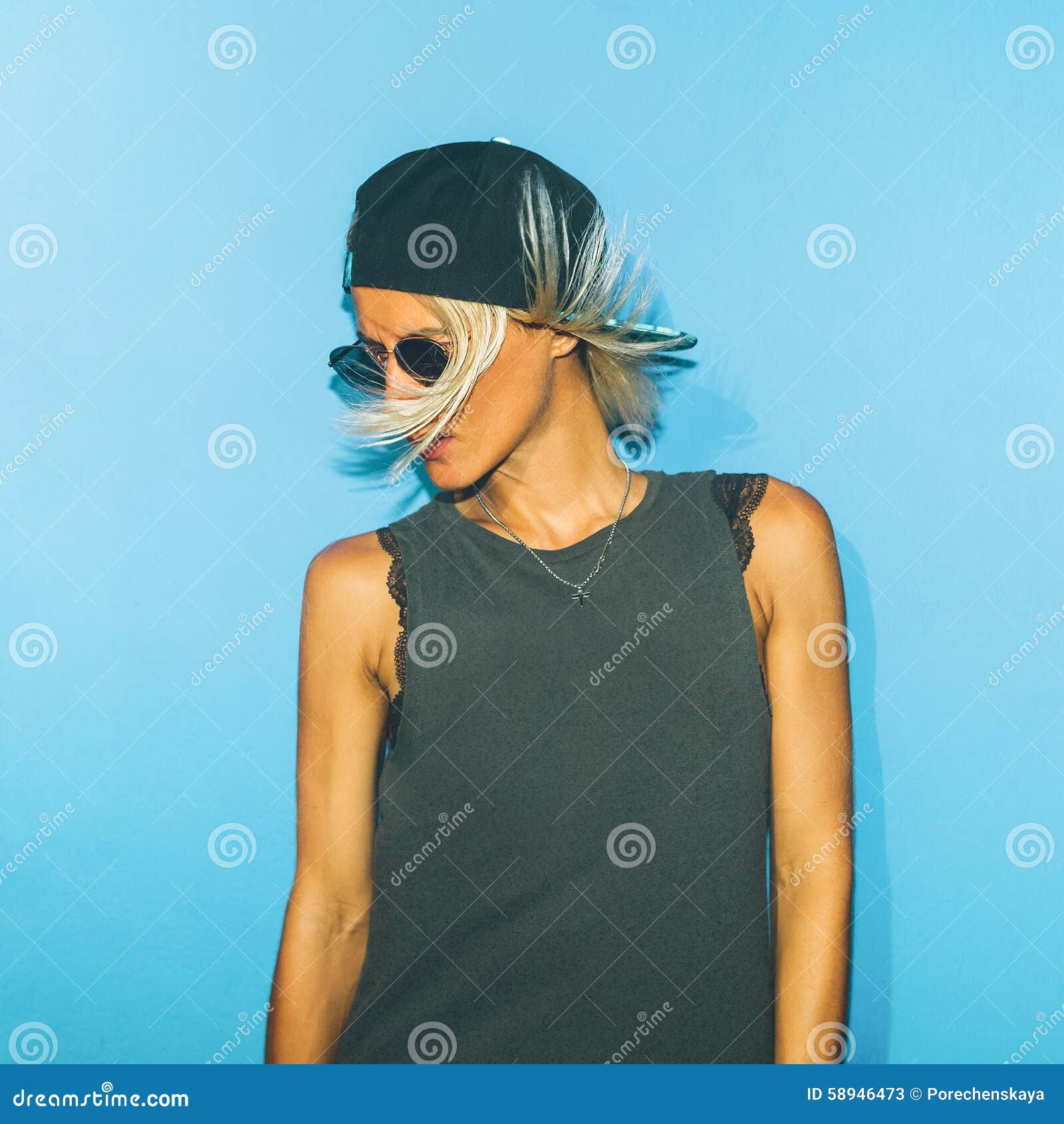 Fashionable Girl Standing on Blue Wall in Stylish Glasses and a Stock ...