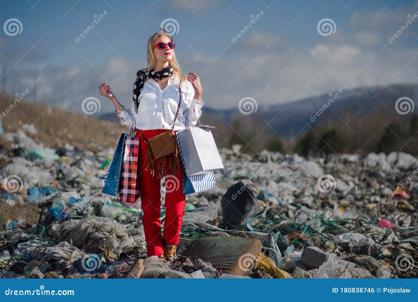 modern woman on landfill, consumerism versus pollution concept.