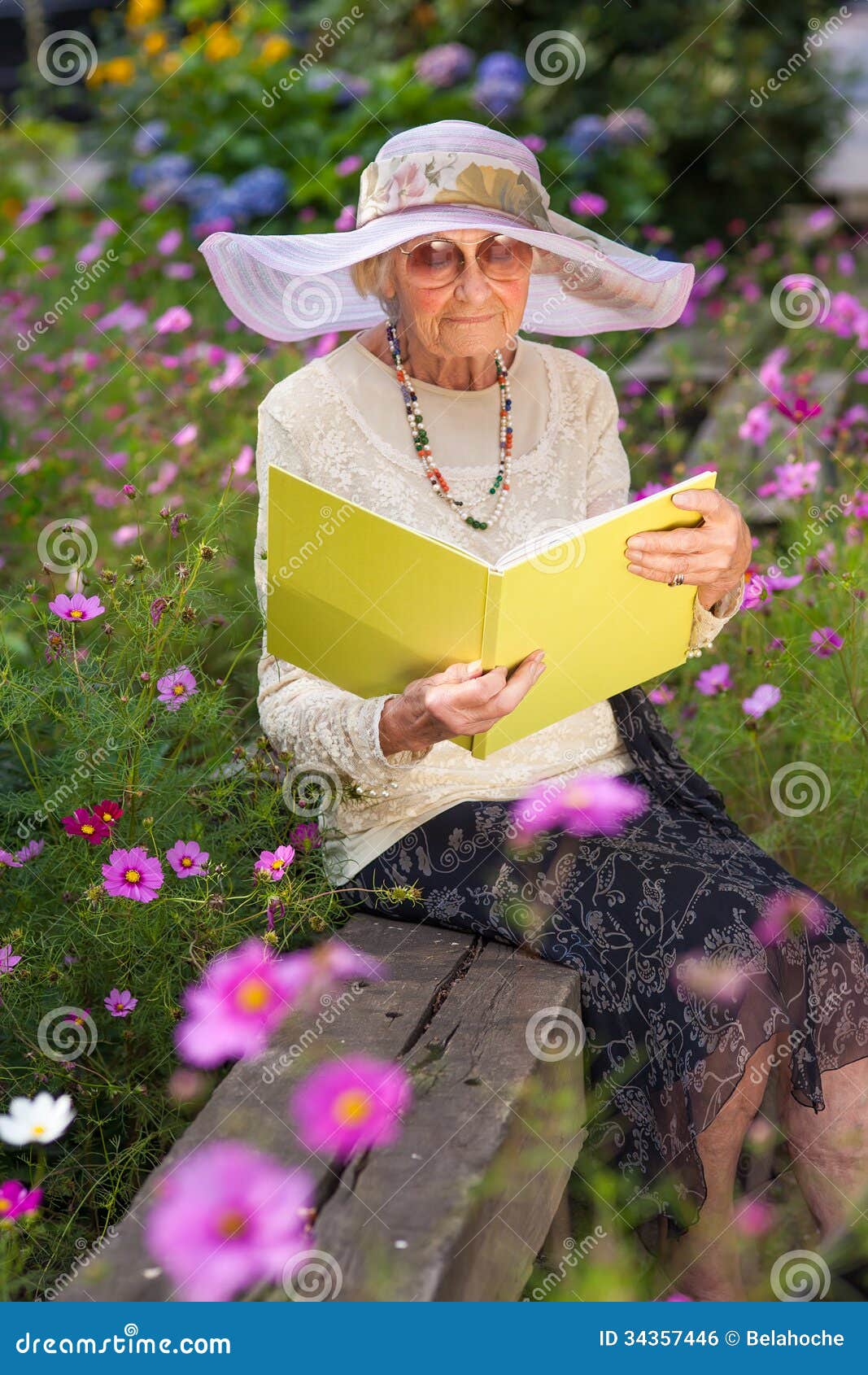 Fashionable Old Lady Reading In Her Garden Stock Photo 