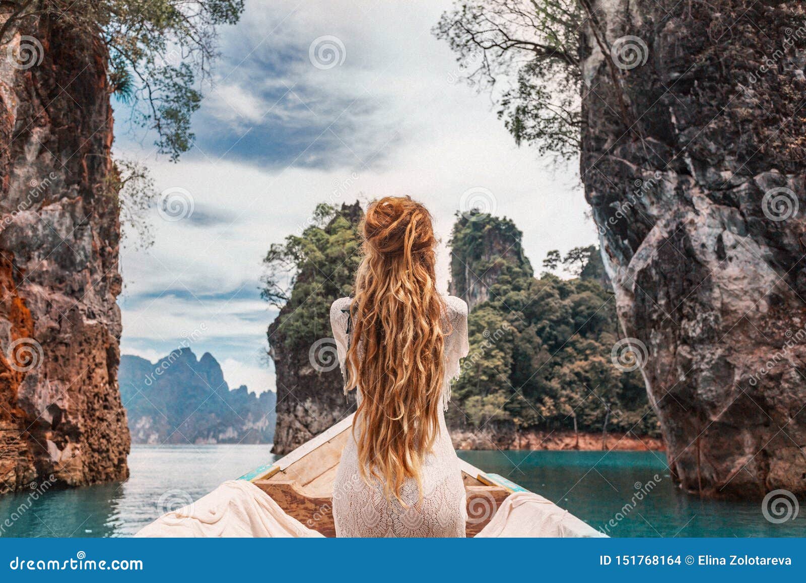 fashionable young model in boho style dress on boat at the lake