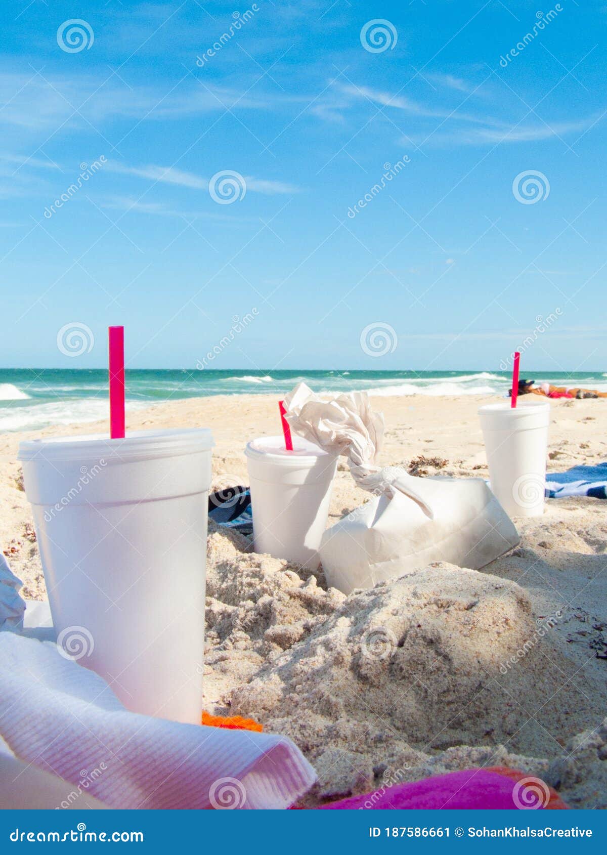 Fast Food Containers and Drink Cups on the Beach with Towels and