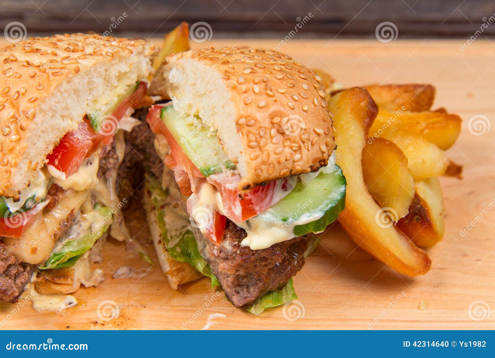 Fast food hamburger and french fries on a wooden plate. look to inside .