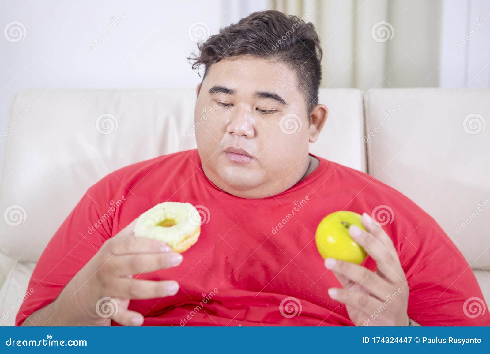 fat-asian-man-confused-doughnut-apple-portrait-sitting-couch-choosing-his-living-room-174324447.jpg
