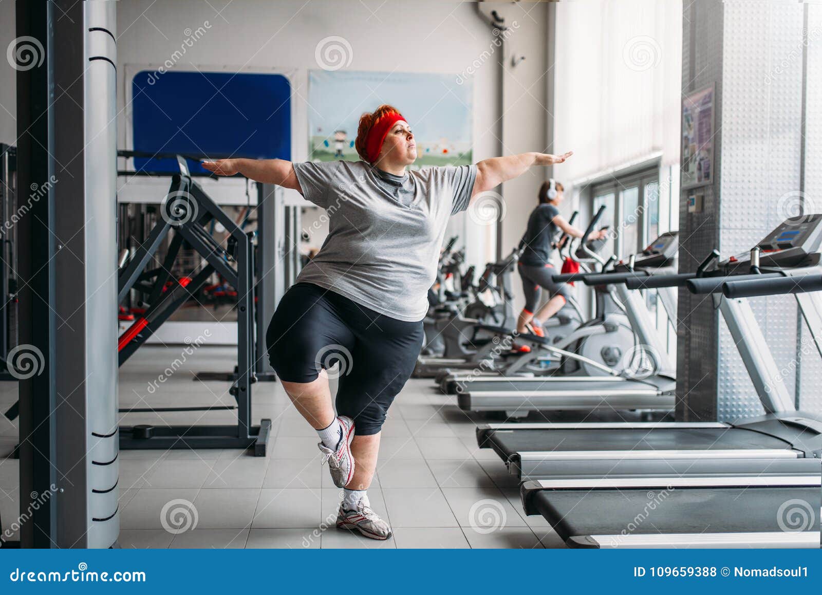 A fat woman is engaged in aerobics and trying to lose weight. An