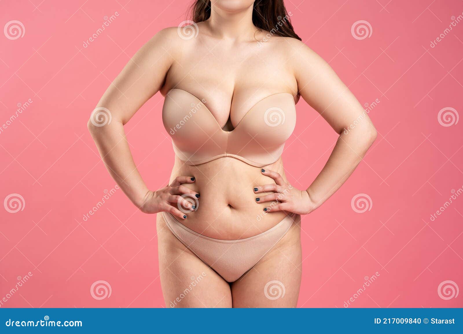 Fat Woman with Large Breasts in a Push-up Bra on Pink Background, Overweight Female Body Stock Photo photo