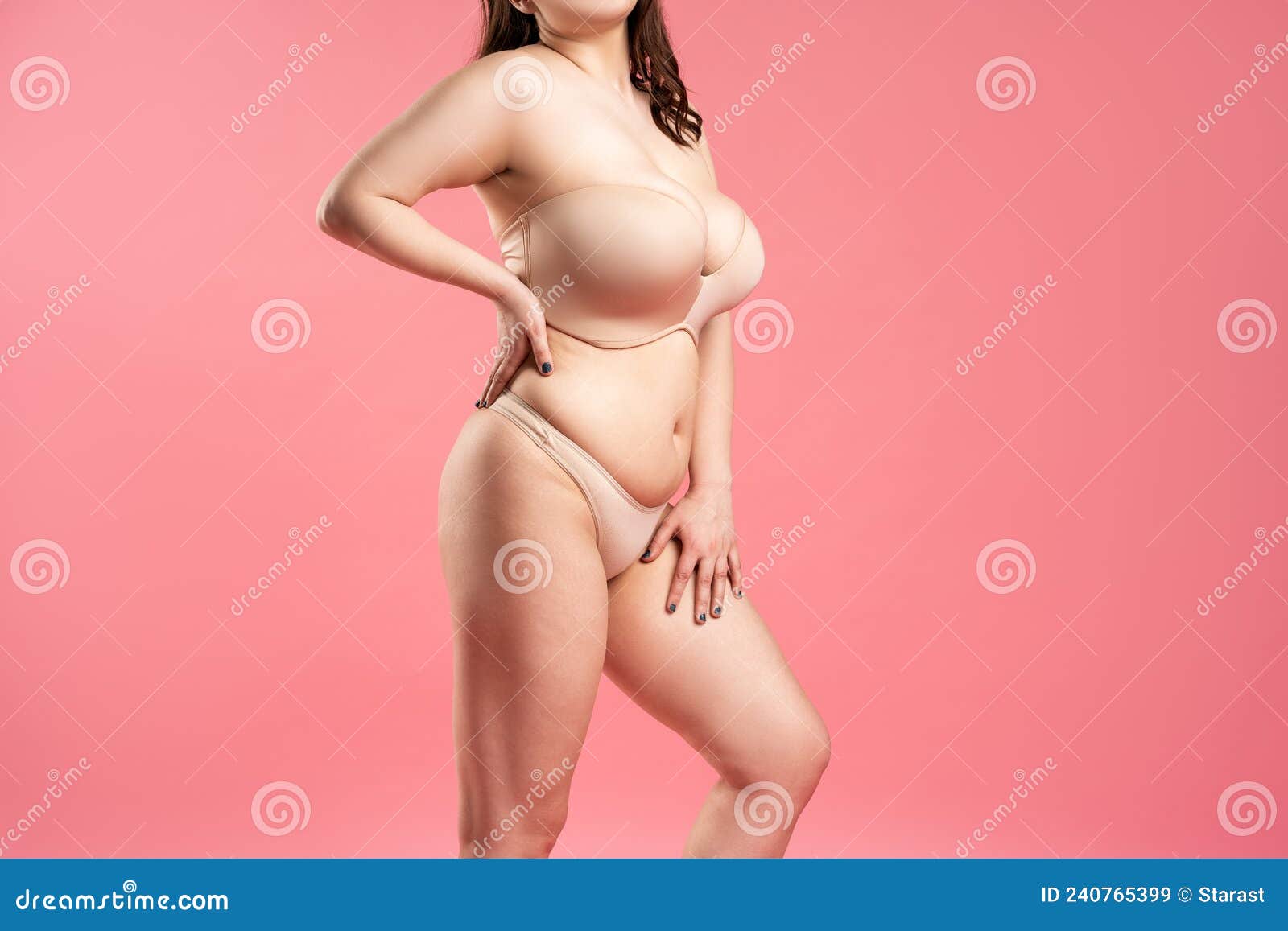 Foto de Very large saggy breasts in orange top bra on gray background do  Stock