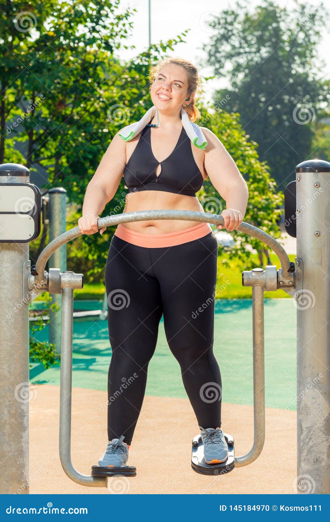Fat Woman in a Sports Top and Leggings is Engaged on a Simulator
