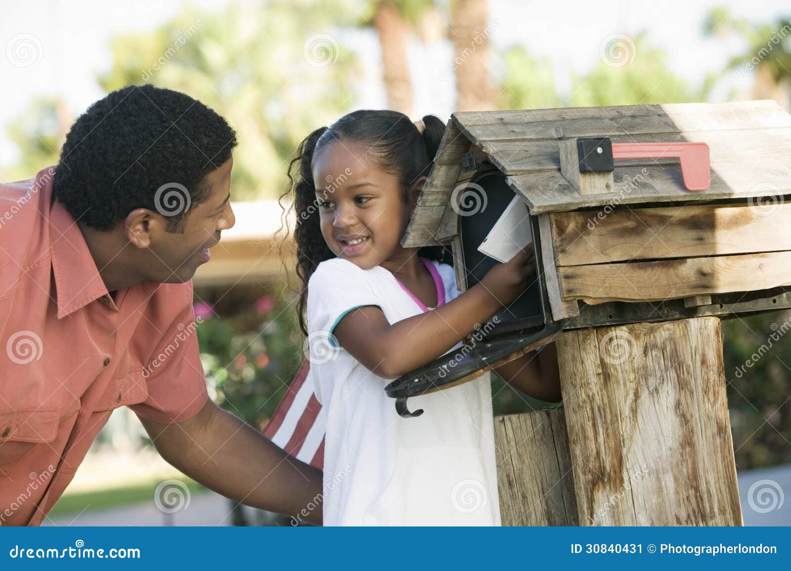 father and daughter checking mail at domestic mailbox