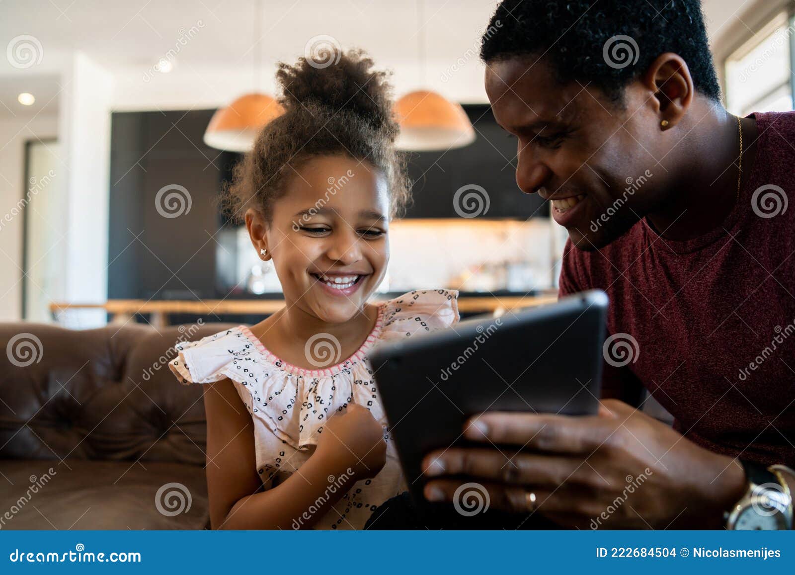 father and daughter using digital tablet at home.