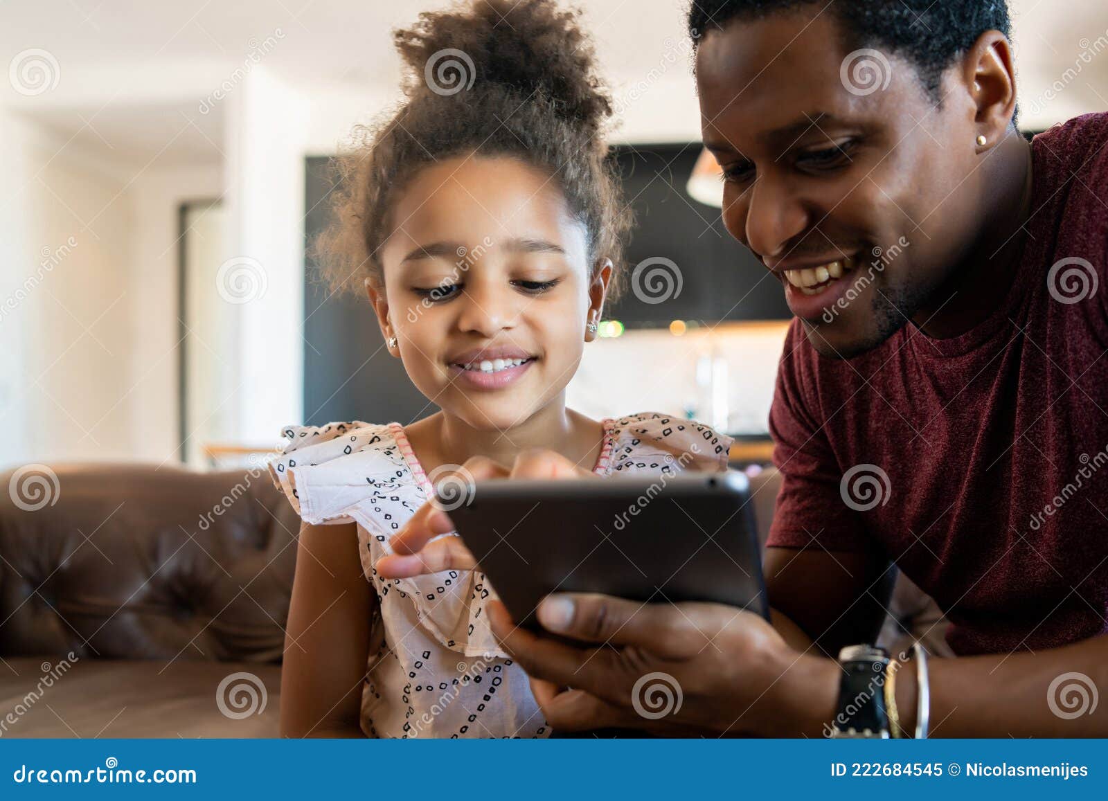 father and daughter using digital tablet at home.