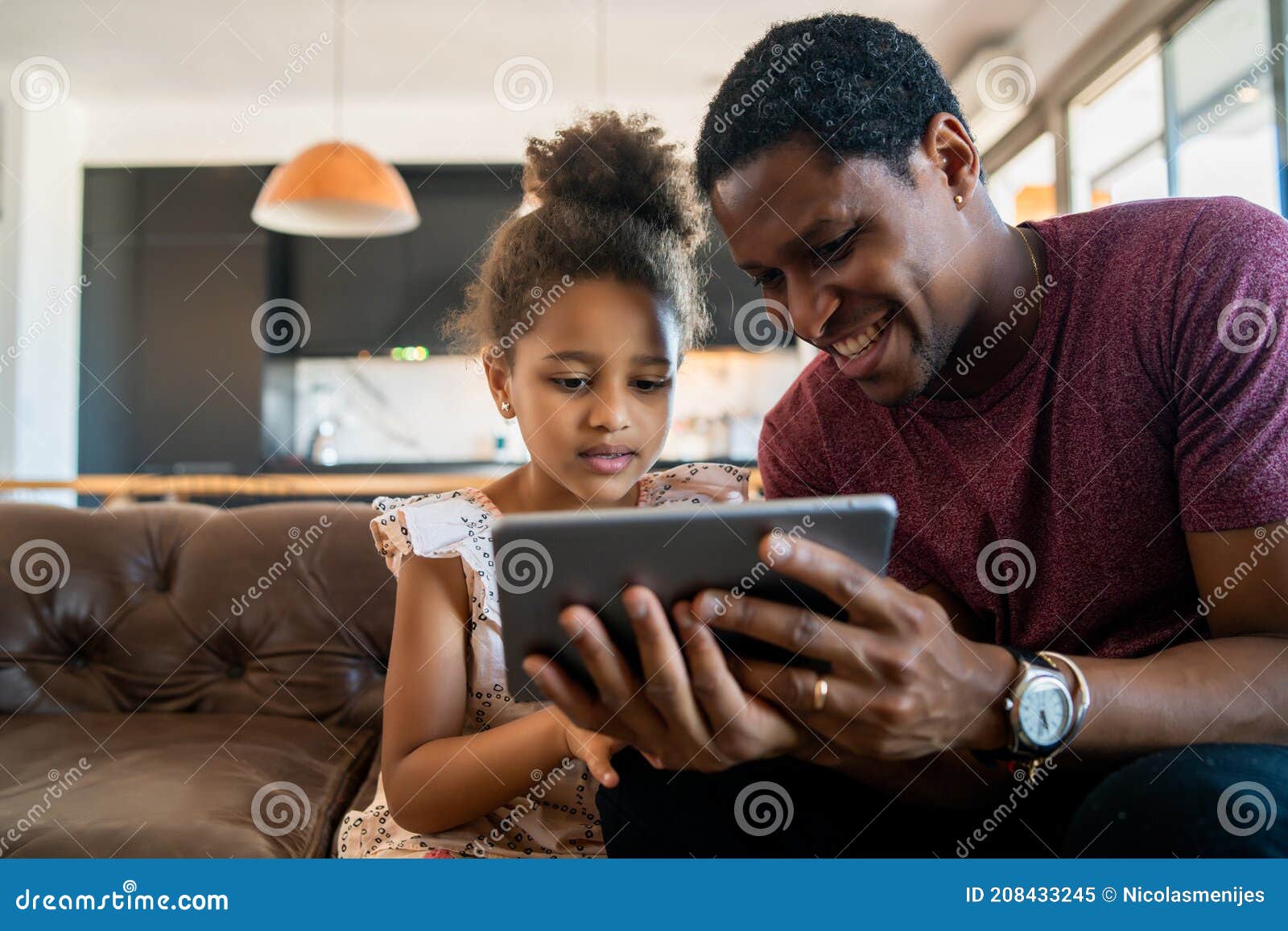 father and daughter using digital tablet at home.