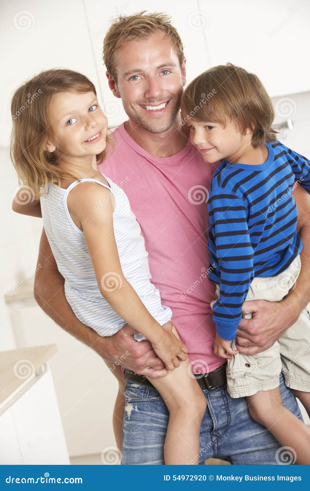 father giving children cuddle at home