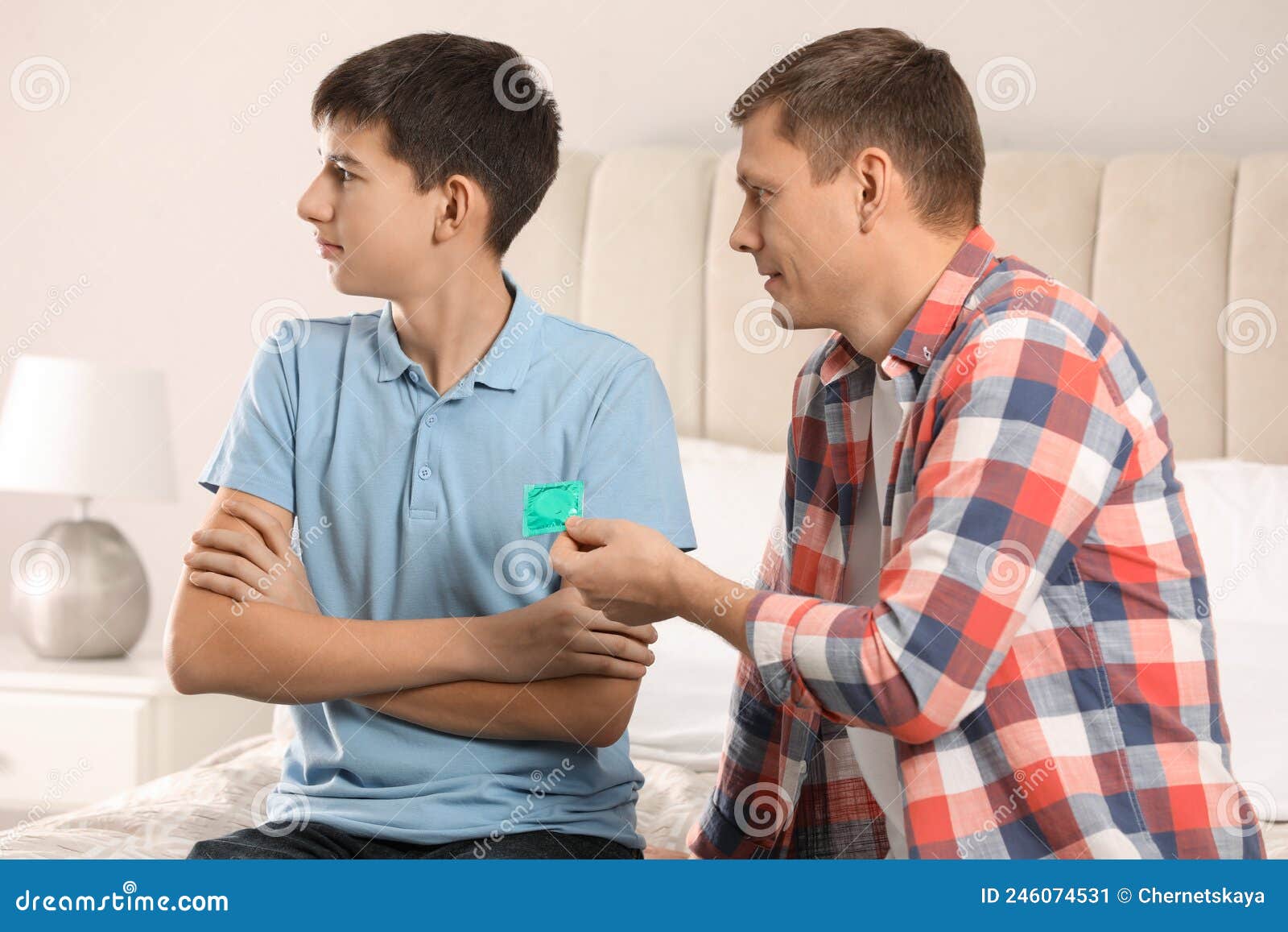 Father Giving Condom To His Teenage Son in Bedroom