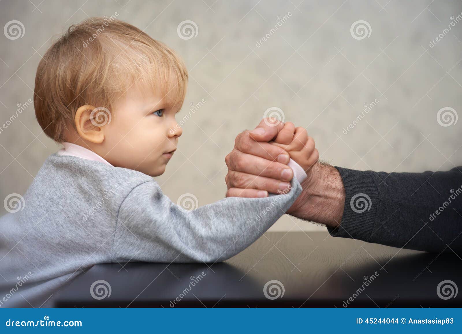 father and kid arm wrestling competition