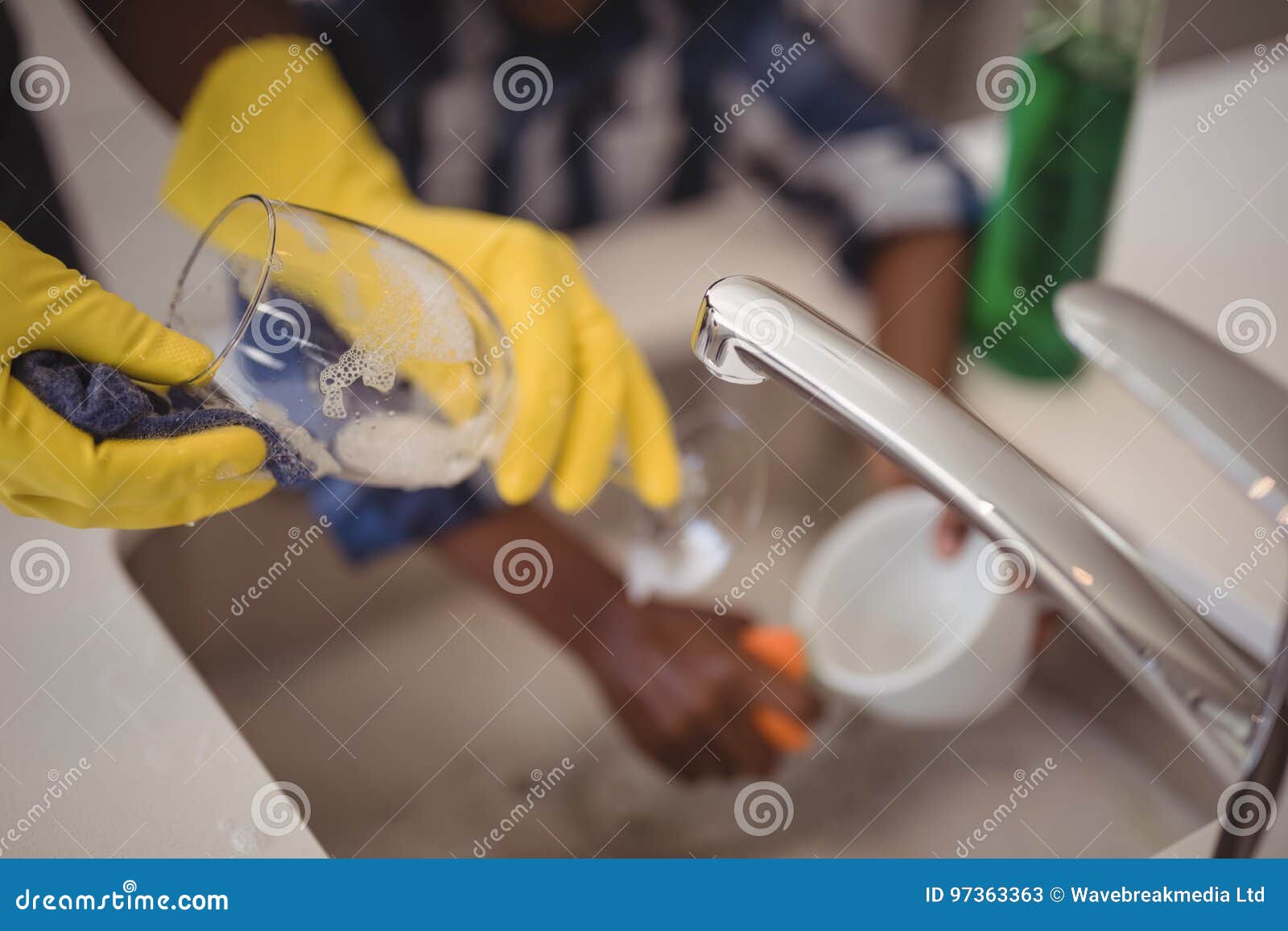Father and Son Cleaning Wine Glass and Cup in Kitchen Stock Image