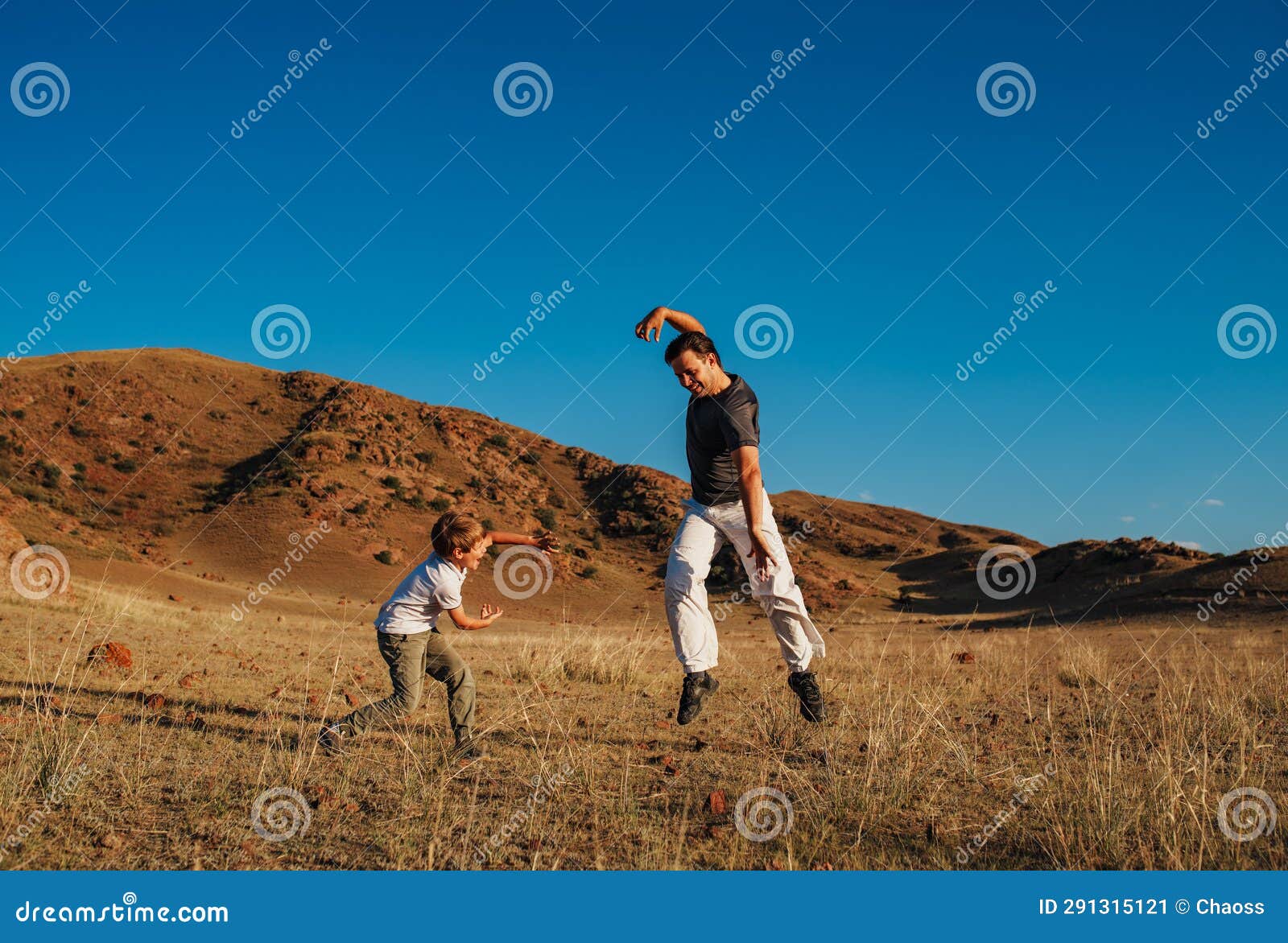 Father and Son Martial Arts Training for Fun on Mountains Background