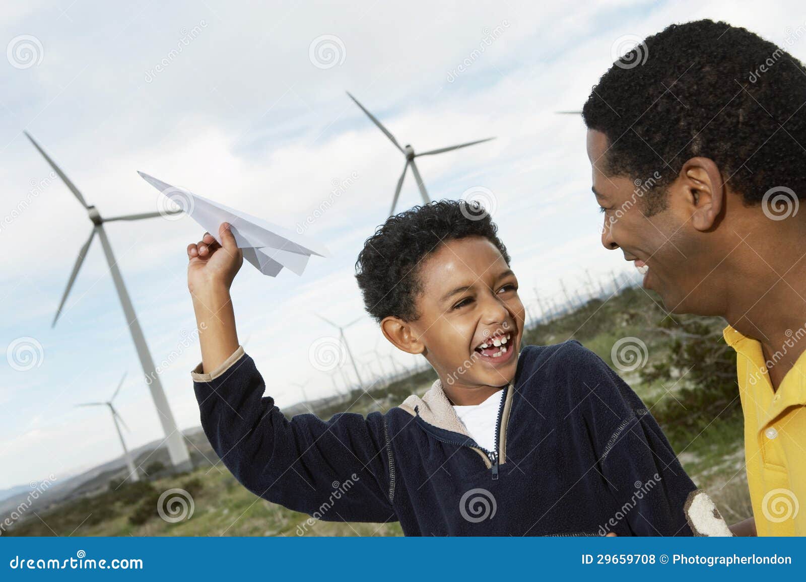father and son playing with paper plane