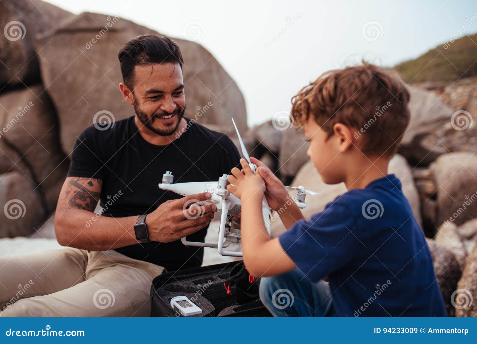 Senior father and his adult son with drone on a field - a Royalty