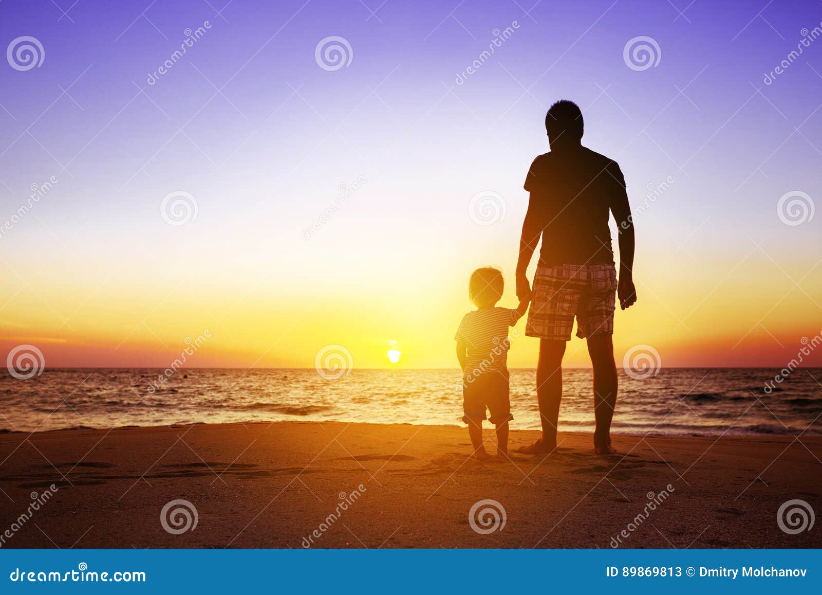 father and son at sunset beach