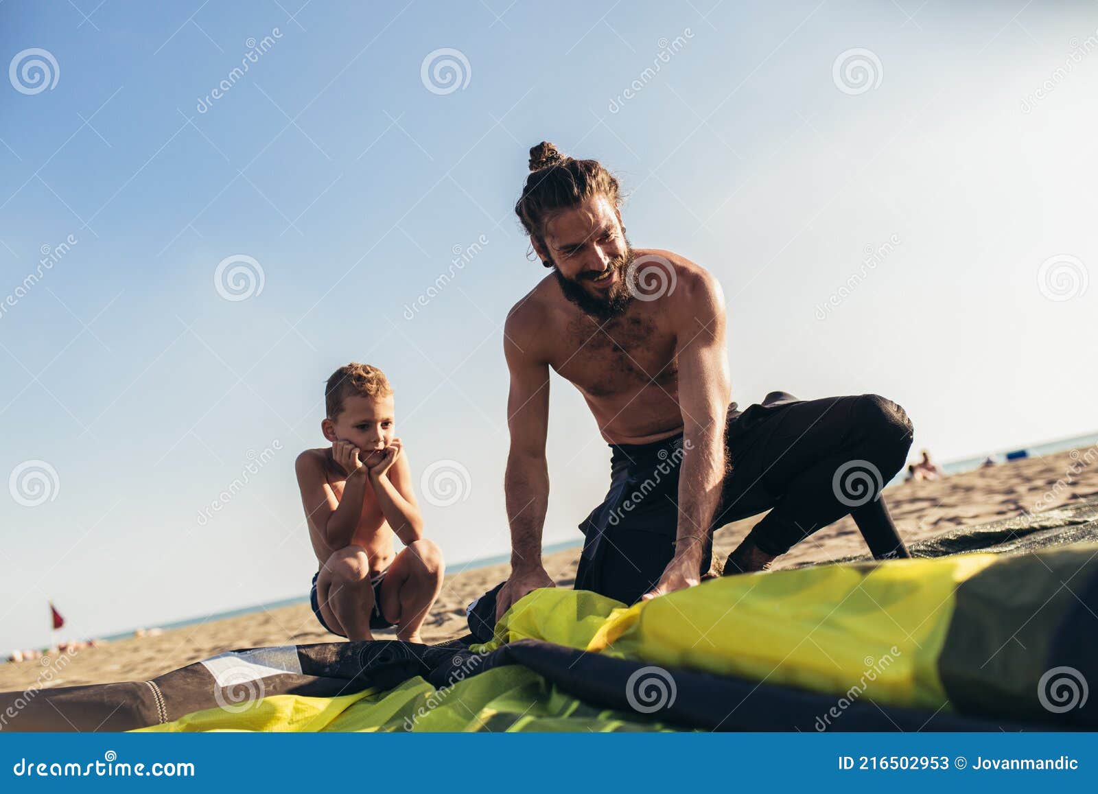 Father and Son in Wetsuits with Kite Equipment for Surfing Stock Image