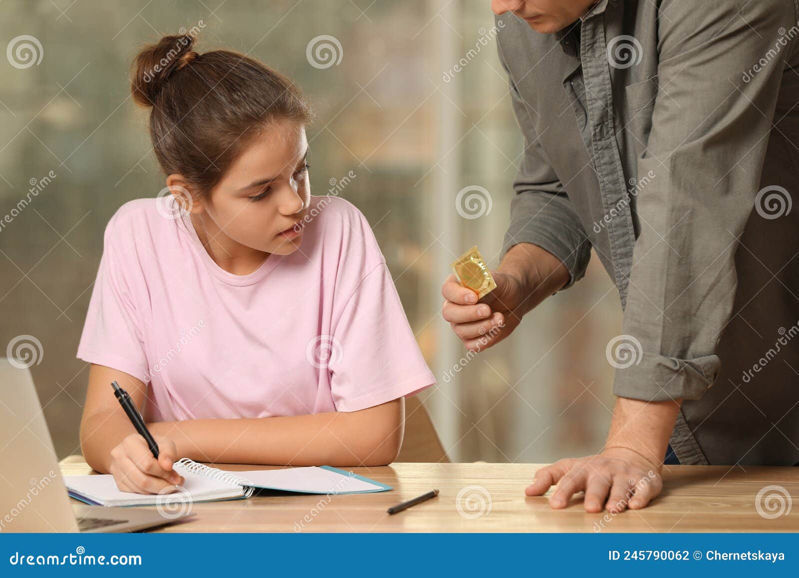 Father Talking with His Teenage Daughter about Contraception while she Doing Homework at Home picture