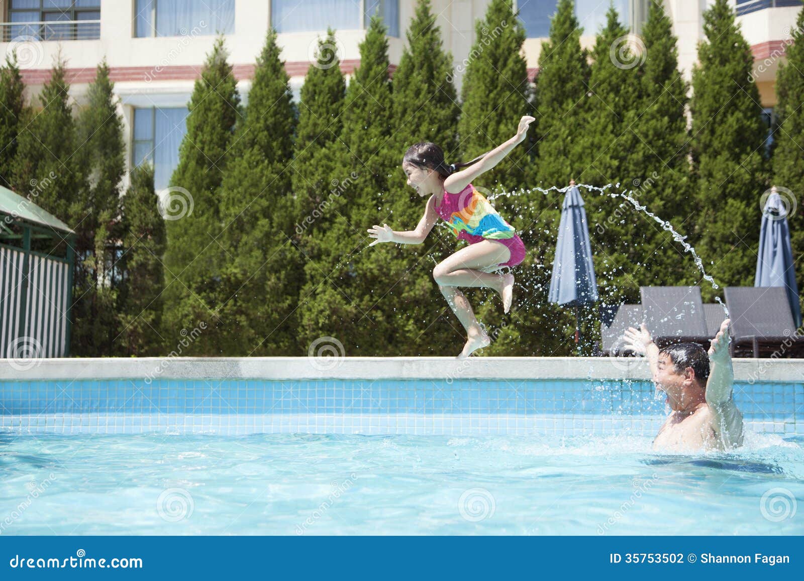Father Throwing Daughter into the Pool, Midair Stock Photo Image of