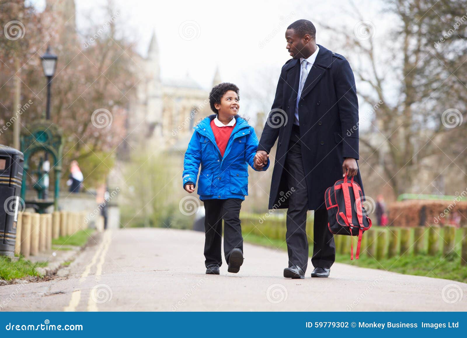 father walking son to school along path