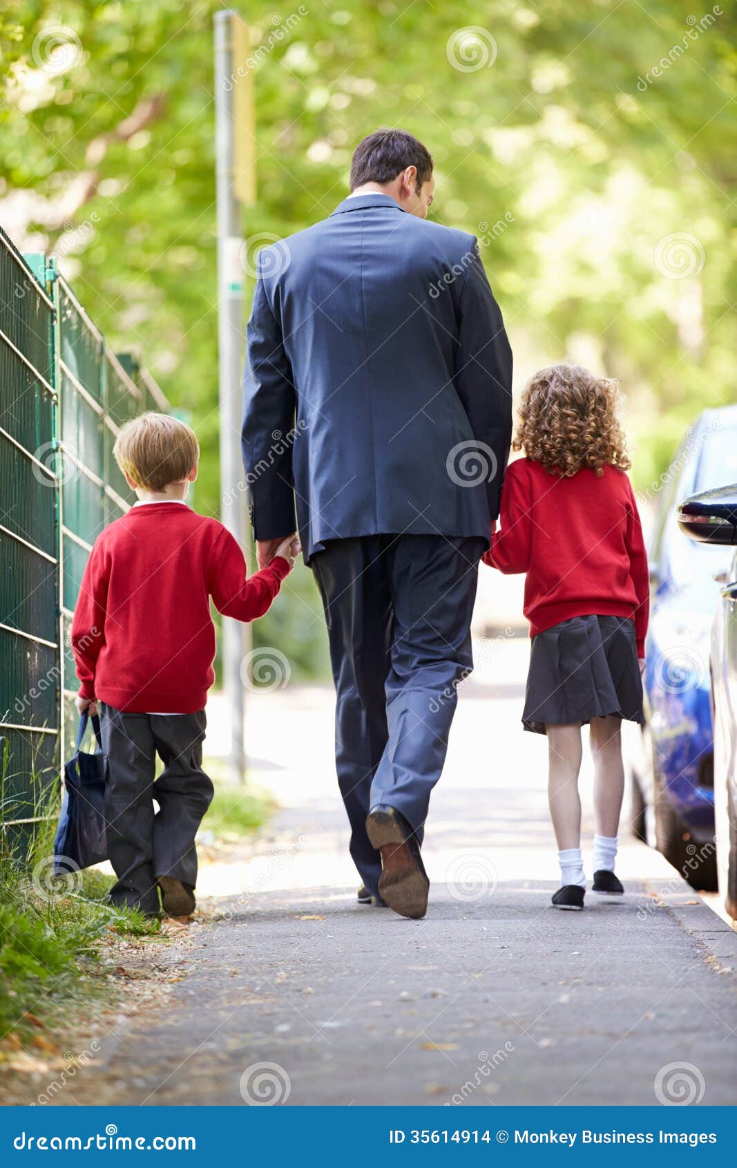 Father Walking To School With Children On Way To Work 