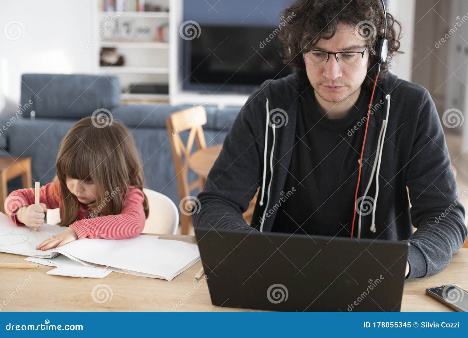 father working from home with little daughter during covid-19 lockdown. front view