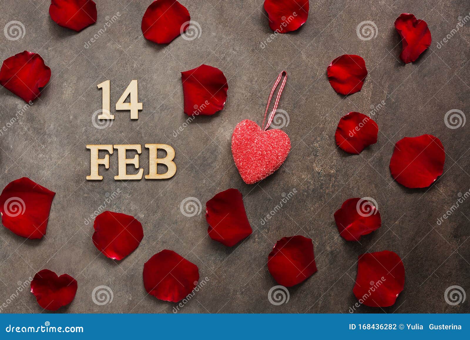 feb 14, valentine`s day. red rose petals and heart on adark brown rustic background. top view, flat lay
