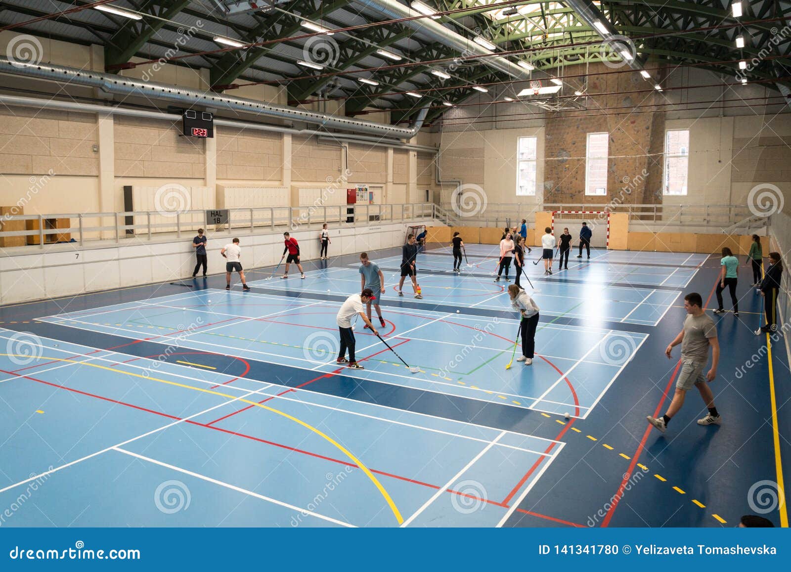 February 21, 2019. Denmark. Copenhagen. Team game with stick and ball Floorball or hockey in hall. Inside training in the gym of the school college. Group of teen caucasian students playing a game
