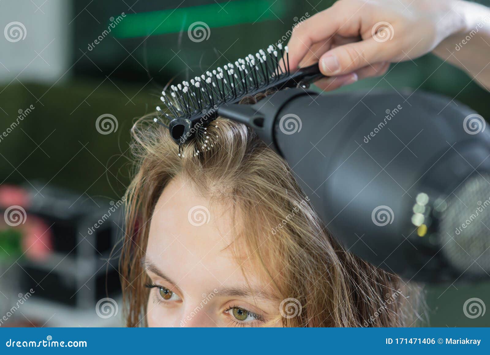 Secador de cabelo, escova de pente nas mãos de cabeleireiros