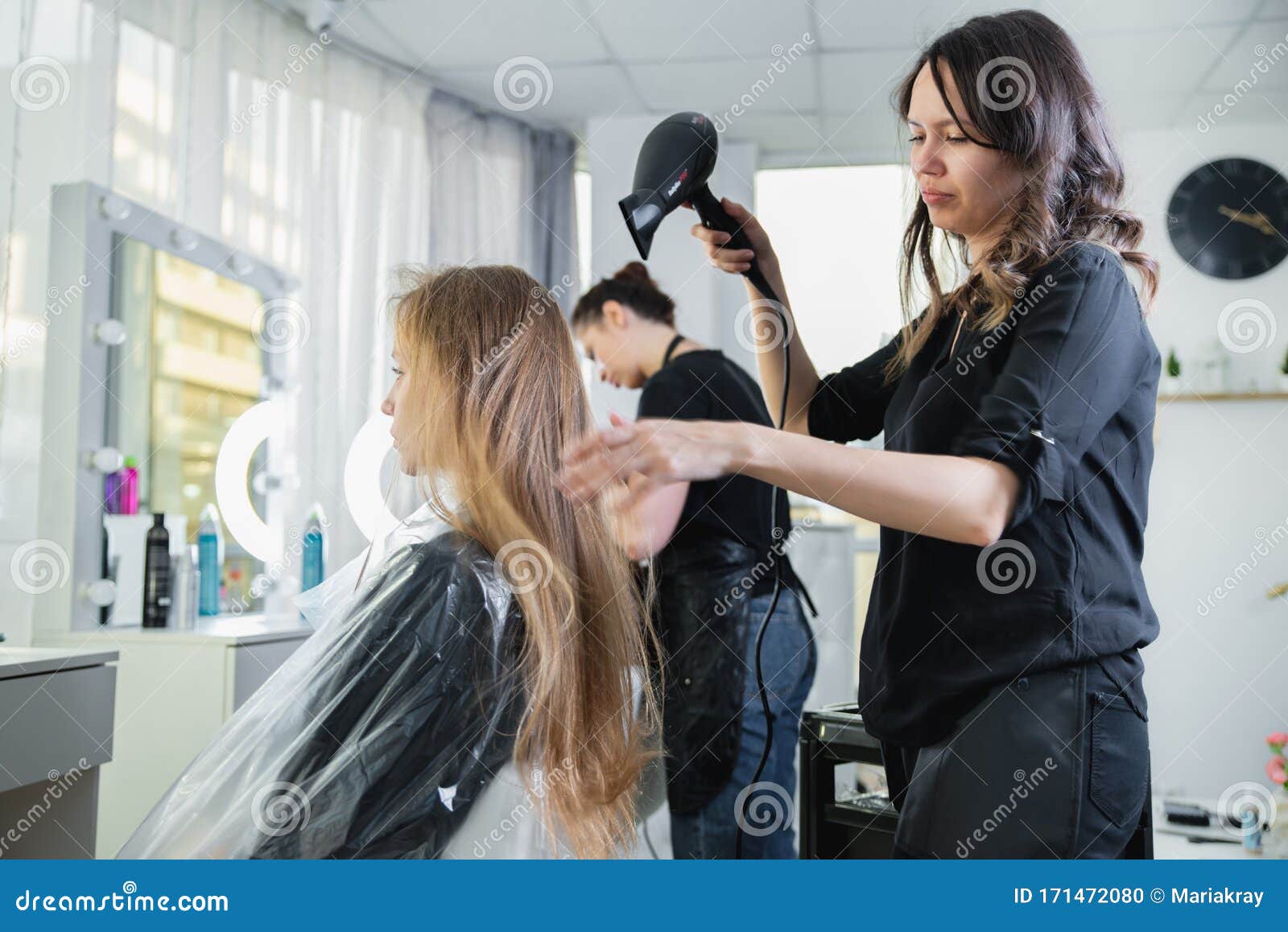 Secador de cabelo, escova de pente nas mãos de cabeleireiros