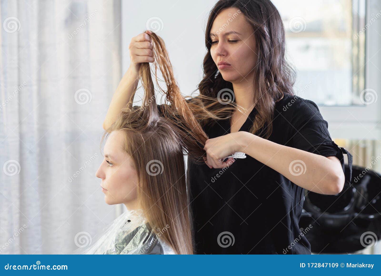 Secador de cabelo, escova de pente nas mãos de cabeleireiros