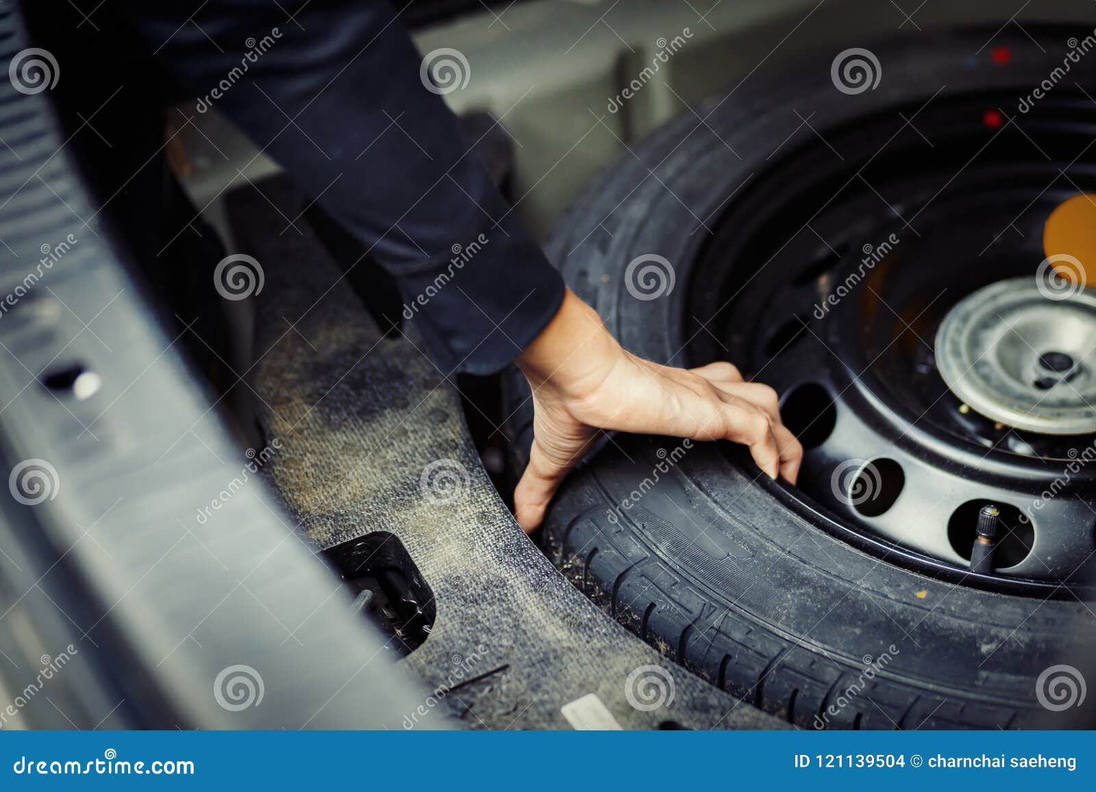 Feche Acima Da Mão Do Mecânico Que Toma O Pneu De Reposição Na Bota No Carro Foto de Stock - Imagem de feche, mão: 121139504